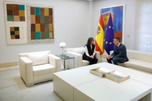 Pedro Sánchez e Francesca Albanese durante un incontro ufficiale alla Moncloa con le bandiere di Spagna e Unione Europea sullo sfondo.
