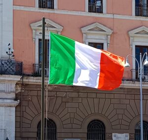 Bandiera italiana davanti al Palazzo della Città di Bari con il Teatro Piccinni sullo sfondo durante la Festa della Repubblica.